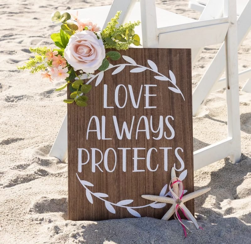 “Love always protects” beach sign